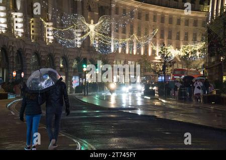 UK Weather, Londra, 12 novembre 2023: Le luci di Natale su Regent Street si riflettono sulle strade bagnate in una notte piovosa. Anna Watson/Alamy Live News Foto Stock