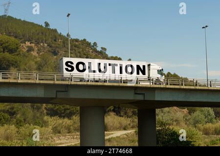 Un veicolo sta attraversando il ponte, con l'iscrizione sul rimorchio - SOLUZIONE. Concetto di logistica. Foto Stock