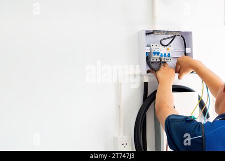 Elettricista maschio certificato che installa il caricabatterie EV domestico Foto Stock