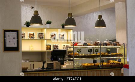 una vetrina in una caffetteria o panetteria con dolci freschi e tre lampade che creano una luce soffusa e un'atmosfera confortevole, una caffetteria o uno snack bar Foto Stock