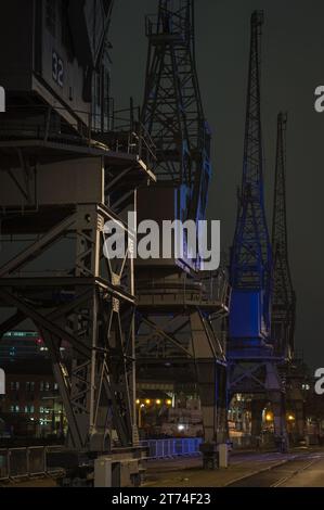 Le gru illuminate lungo il lungomare di fronte al M-Shed nel bacino di Cumberland, Bristol Docks, Bristol, Somerset, Inghilterra, REGNO UNITO Foto Stock