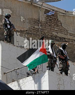 Gli yemeniti tengono in mano bandiere palestinesi, ballano e cavalcano una bicicletta durante una veglia per mostrare solidarietà al popolo palestinese, a Sana'a, Yemen, il 13 novembre 2023. Migliaia di israeliani e palestinesi sono morti da quando il gruppo militante Hamas ha lanciato un attacco senza precedenti contro Israele dalla Striscia di Gaza il 7 ottobre e gli scioperi israeliani sull'enclave palestinese. Foto Stock