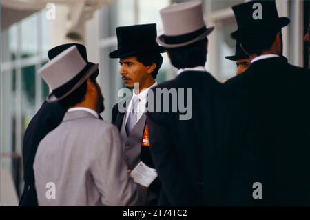 Uomini arabi in abiti occidentali, cappotti a coda e cappello che fanno tutti parte dell'entourage dello sceicco Mohammed al Maktoum al Royal Ascot, nel Members Enclosure. Berkshire, Inghilterra, circa giugno 1983. 1980S UK HOMER SYKES Foto Stock