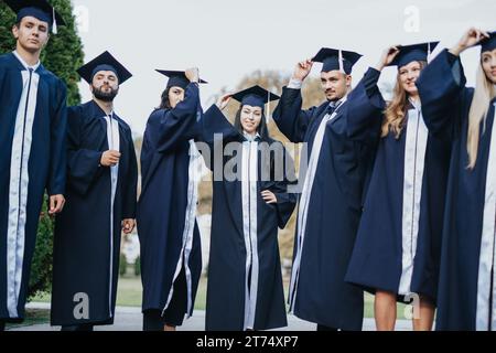 I laureati dell'università multietnica celebrano il successo a Sunny Park Foto Stock