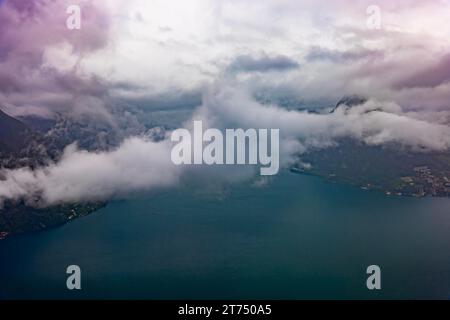 Vista aerea sulla città e sul lago di Lugano in Valle con paesaggio montano con nuvole di tempesta a Lugano, Ticino, Svizzera Foto Stock