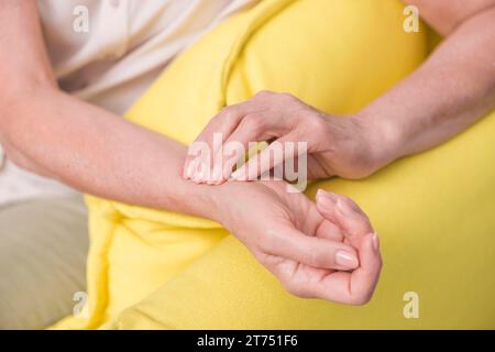 Primo piano mano di una donna che controlla il polso Foto Stock