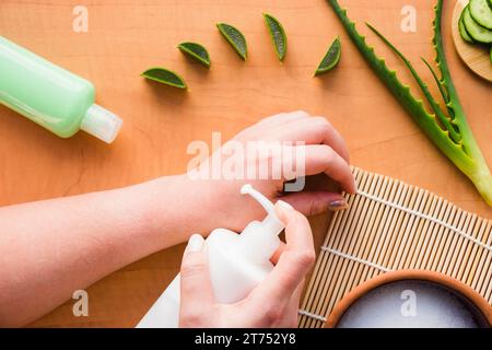 Mani che applicano crema di aloe vera Foto Stock