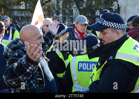 Ha incontrato gli agenti di polizia interrogare e perquisire contro i dimostranti prima dell'inizio della marcia pro-palestinese il giorno dell'armistizio dell'11 novembre 2023. Foto Stock