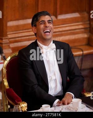 Il primo Ministro Rishi Sunak ride mentre ascolta l'Arcivescovo di Canterbury Justin Welby parlare all'annuale Lord Mayor's Banquet alla Guildhall nel centro di Londra. Data immagine: Lunedì 13 novembre 2023. Foto Stock