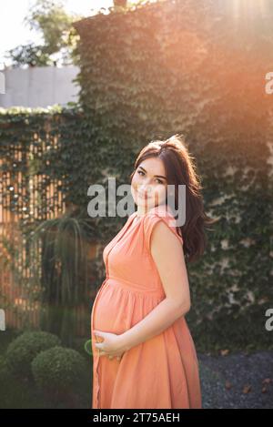 Donna incinta con tiratura media che posa all'aperto Foto Stock
