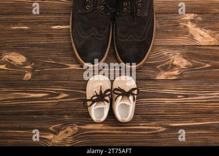 Scarpe maschili vicino a stivali per bambini Foto Stock