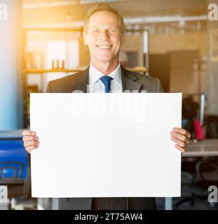 Ritratto uomo d'affari maturo sorridente con un cartello vuoto Foto Stock