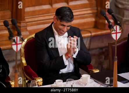 Il primo Ministro Rishi Sunak ride mentre ascolta l'Arcivescovo di Canterbury Justin Welby parlare all'annuale Lord Mayor's Banquet alla Guildhall nel centro di Londra. Data immagine: Lunedì 13 novembre 2023. Foto Stock