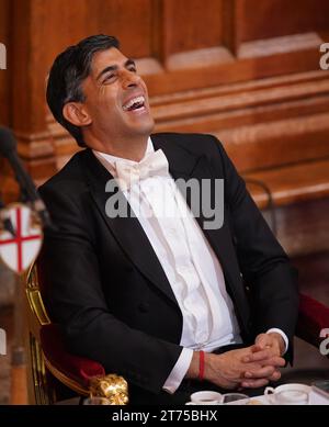 Il primo Ministro Rishi Sunak ride mentre ascolta l'Arcivescovo di Canterbury Justin Welby parlare all'annuale Lord Mayor's Banquet alla Guildhall nel centro di Londra. Data immagine: Lunedì 13 novembre 2023. Foto Stock