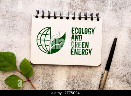 Tra due fogli di un quaderno su una striscia verde con la scritta "Ecology and Green Energy" Foto Stock