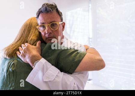 Ritratto di un medico serio che abbraccia una paziente dopo averle dato cattive notizie Foto Stock