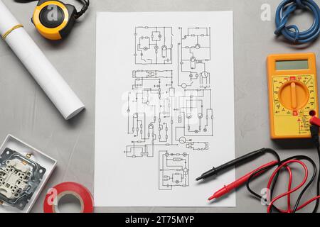 Schema elettrico, fili e multimetro digitale su tavolo grigio chiaro, posizionamento piatto Foto Stock