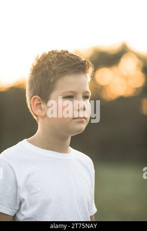 Un ragazzino americano sconvolto guarda la macchina fotografica con il volto confuso fuori. Deluso prescolero caucasico perplesso. Foto Stock