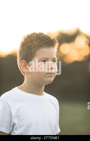 Un ragazzino americano sconvolto guarda la macchina fotografica con il volto confuso fuori. Deluso prescolero caucasico perplesso. Foto Stock