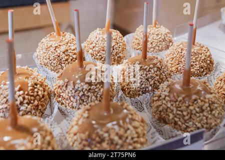 Un vassoio di mele caramellate cosparse di noci è esposto in un mercato in autunno. Foto Stock