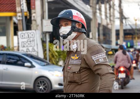 SAMUT PRAKAN, THAILANDIA, 11 novembre 2023, Un poliziotto dirige il traffico al crepuscolo sulla strada Foto Stock