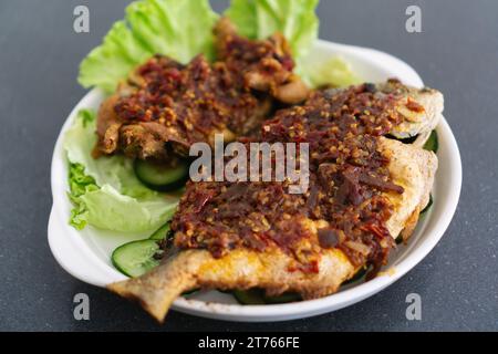 Ikan Goreng Masak Sambal, pesce fritto con pasta di Cile. Piatto tradizionale indonesiano e malese Foto Stock