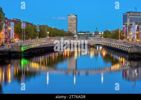 Il fiume Liffey e il famoso Ha'penny Bridge a Dublino, Irlanda, al crepuscolo Foto Stock