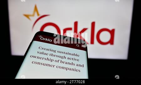 Smartphone con sito Web dell'azienda norvegese Orkla ASA davanti al logo aziendale. Mettere a fuoco in alto a sinistra sul display del telefono. Foto Stock