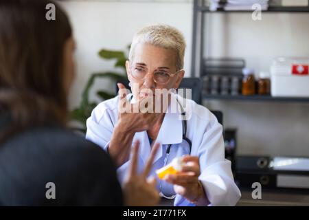 Medico che dà pillola al paziente femminile presso lo studio medico in ospedale. medicina, concetto sanitario Foto Stock