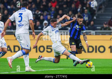 Milano, Italia. 12 novembre 2023. Lautaro Martinez del FC Internazionale (R) compete per il pallone con Ilario Monterisi del Frosinone calcio (L) durante la partita di serie A 2023/24 tra FC Internazionale e Frosinone calcio allo Stadio Giuseppe Meazza. PUNTEGGIO FINALE: Inter 2 | 0 Frosinone credito: SOPA Images Limited/Alamy Live News Foto Stock