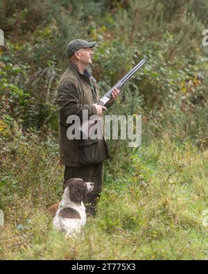 un uomo con un cane springer spaniel al tiro Foto Stock