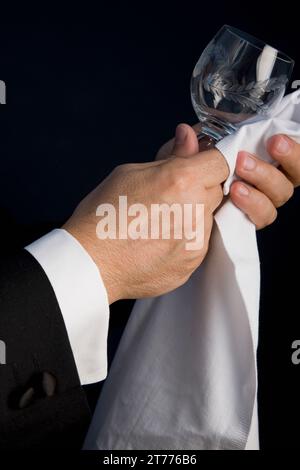 Close up di un cameriere di mani la lucidatura di un vetro cristallo Foto Stock