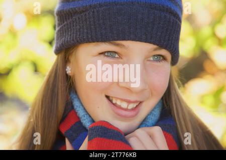 Giovane ragazza sorridente che indossa un cappello di lana Foto Stock