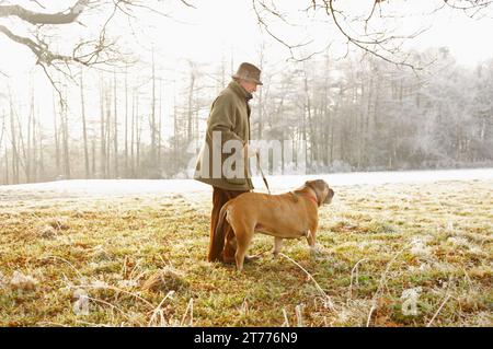 Profilo di un uomo maturo a piedi un cane nel parco Foto Stock