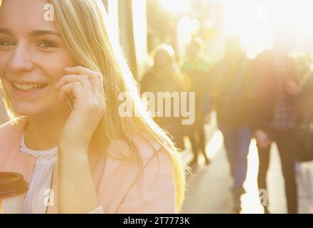 Donna che parla al cellulare su una strada di città Foto Stock