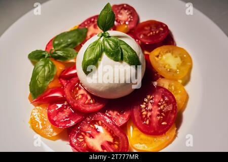 Primo piano dell'insalata caprese fresca STILL Life con succosi pomodori, mozzarella montata e basilico fresco Foto Stock
