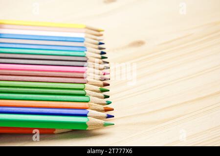 primo piano di molte matite di colori diversi su un tavolo di legno Foto Stock