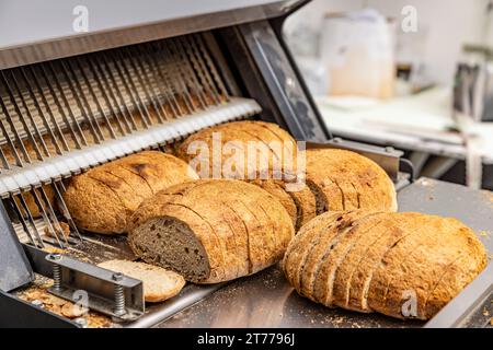 Macchina per affettare il pane nella linea di produzione di prodotti da forno Foto Stock