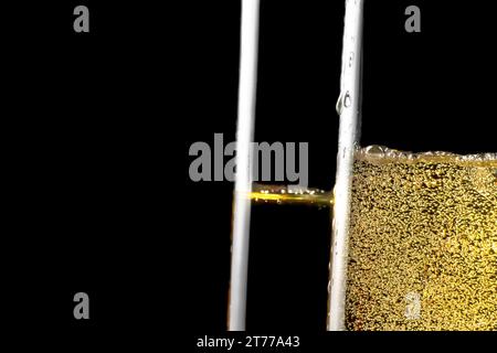 dettaglio di un paio di flute di champagne con bolle d'oro su sfondo nero e spazio per il testo Foto Stock