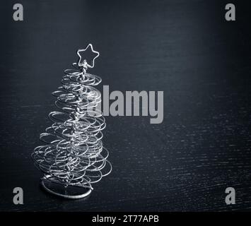 dettaglio di moderno albero di natale in argento su tavolo in legno con spazio per il testo Foto Stock