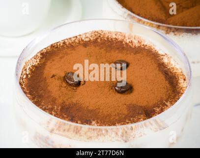 dessert italiano al tiramisù servito in una tazza con chicchi di caffè Foto Stock