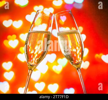 un paio di flauti di champagne con bolle d'oro fa il tifo per il cuore, il concetto di san valentino Foto Stock
