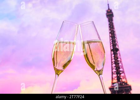 Un paio di flauti di champagne con bolle d'oro fanno il tifo sulla torre sfocata sfondo Eiffel concetto di san valentino Foto Stock