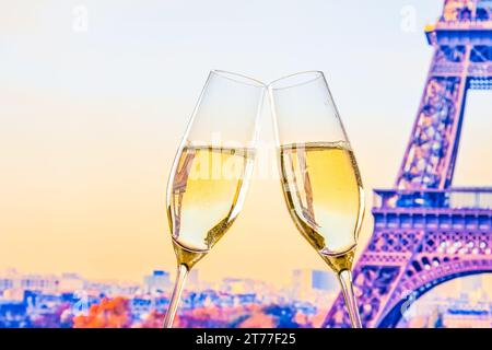 Un paio di flauti di champagne con bolle d'oro fanno il tifo sulla torre sfocata sfondo Eiffel concetto di san valentino Foto Stock