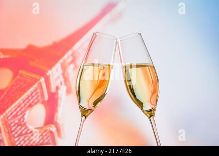 Un paio di flauti di champagne con bolle d'oro fanno il tifo sulla torre sfocata sfondo Eiffel concetto di san valentino Foto Stock