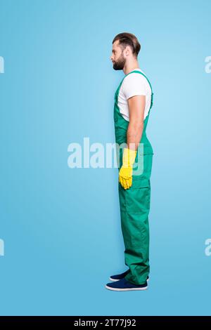 Vista laterale mezzo viso snap, full size ritratto di virile aspro barbuto concentrato uomo con barba corta, acconciatura in uniforme verde, isolato su Foto Stock