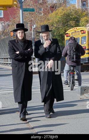 2 ebrei ortodossi, possibilmente familiari, camminano su Lee Avenue a Brooklyn in una fredda domenica autunnale. Foto Stock