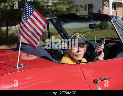 Un anziano veterano dell'esercito cavalca in una delle auto principali durante l'annuale Veterans Day Parade a Somers, New York, l'11 novembre 2023. Foto Stock