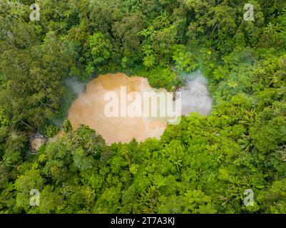 Vista dall'alto del lago AGCO Mud Spa, lago naturale di fango solforico bollente e acque riscaldate dalle bocche vulcaniche sotterranee. Monte Apo a Mindanao, Filippine. Foto Stock