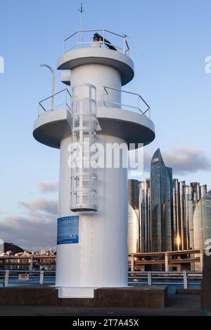 Busan, Corea del Sud - 16 marzo 2018: La torre bianca del faro sorge su un frangiflutti all'ingresso del vecchio porto di pescatori della città di Busan Foto Stock